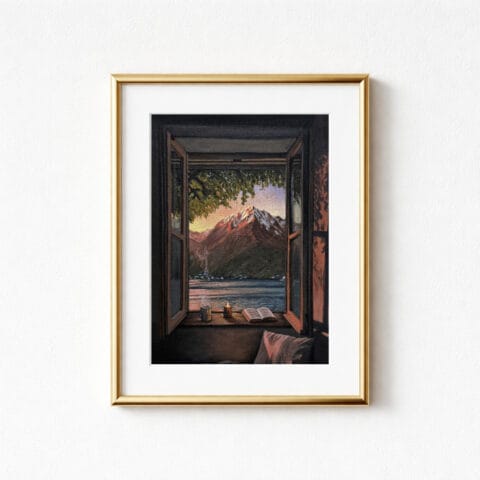 A framed print showing a scenic view through an open window. The artwork features a mountain range, a lake, and a candle, book, and mug on the windowsill. The frame is gold.